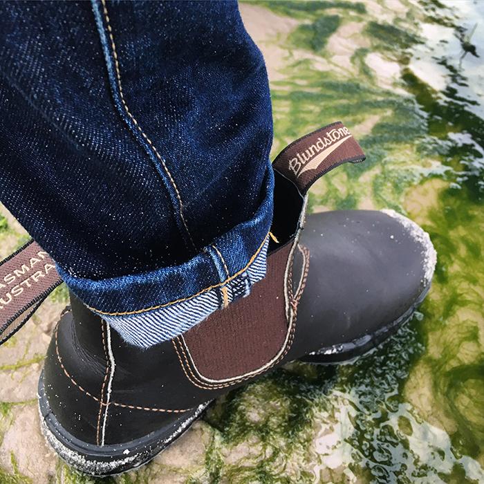 Close up of Danner boots boots, stepping through a creek.