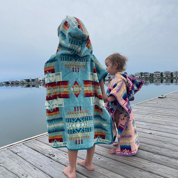 Kids on a pier wearing Pendleton Hooded Beach Towels.